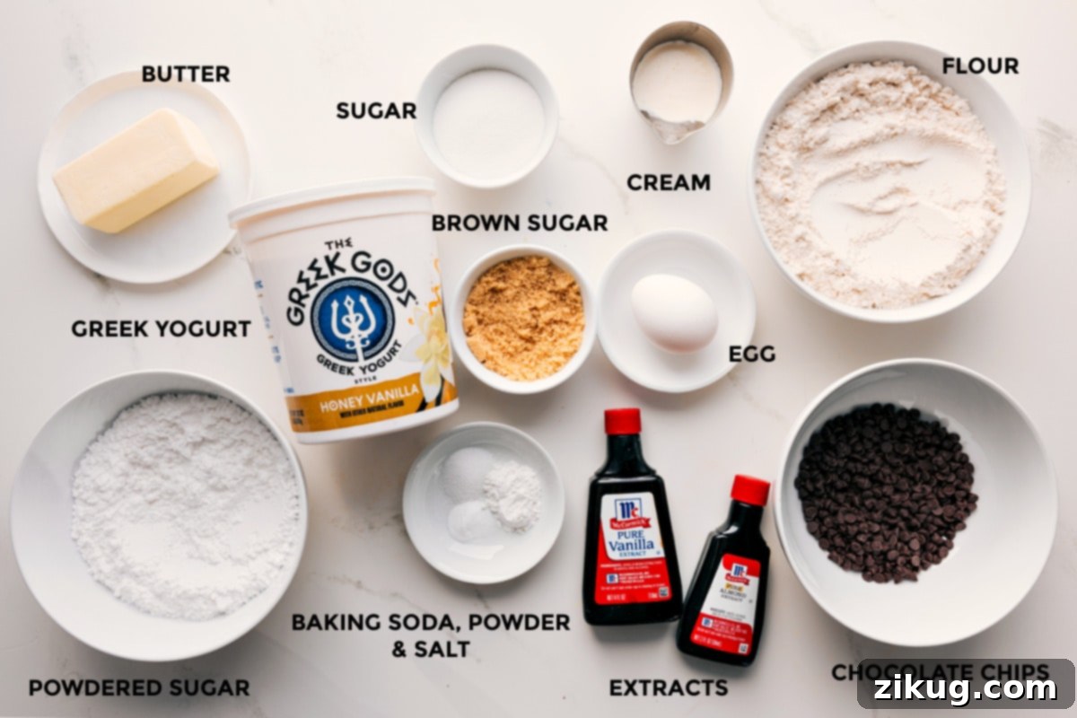 Ingredients In Chocolate Chip Scones A beautifully arranged spread of all the essential ingredients for chocolate chip scones, including cold butter, various sugars, Greek yogurt, baking agents, cream, egg, extracts, and mini chocolate chips, meticulously prepped for baking.