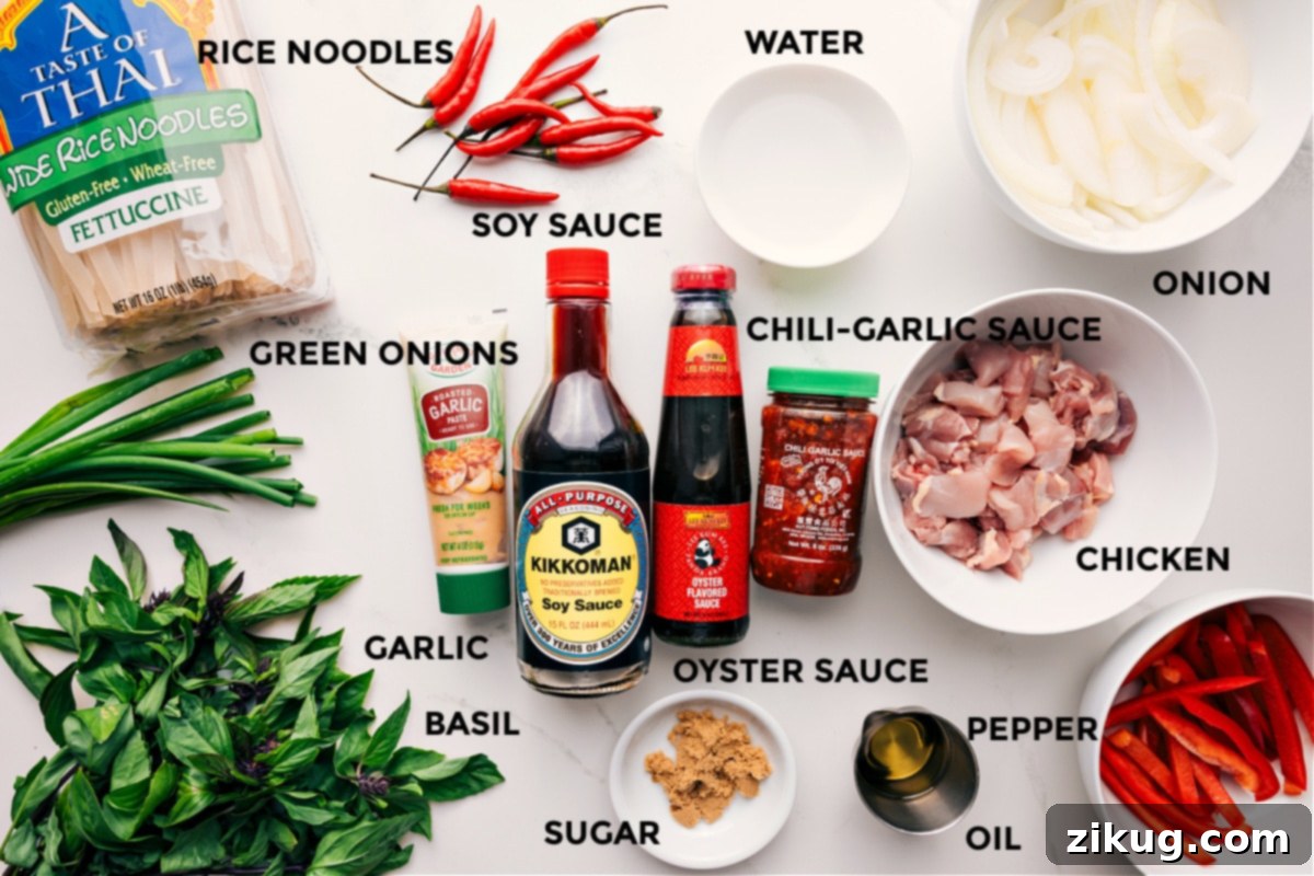 Ingredients In Thai Drunken Noodles (Pad Kee Mao) Recipe All the essential ingredients for making Thai Drunken Noodles prepped and laid out, including wide rice noodles, fresh green onions, minced garlic, aromatic basil, soy sauce, spicy chili garlic sauce, rich oyster sauce, brown sugar, cooking oil, black pepper, sliced chicken, onion, and a bit of water.