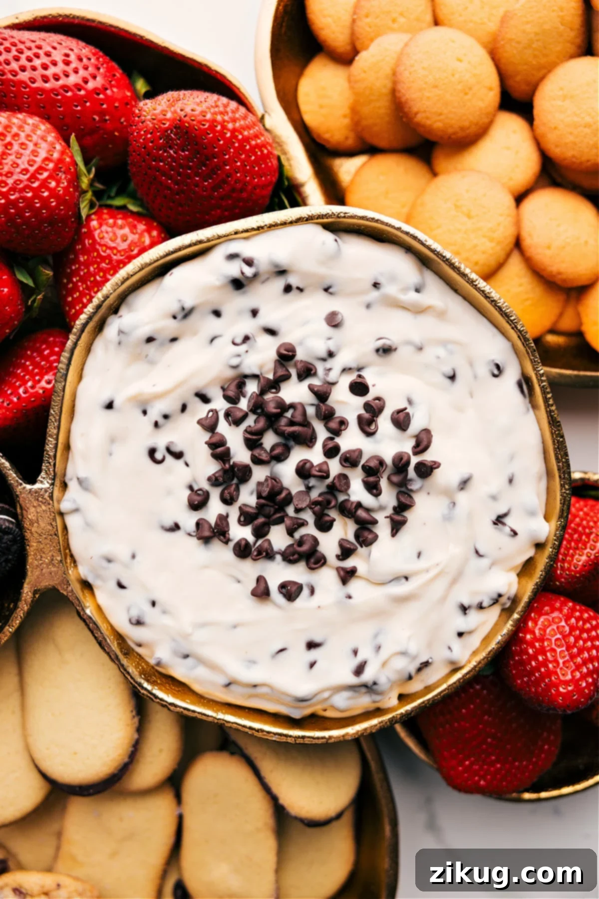 Indulge In the Best Chocolate Chip Dip Decadent Chocolate Chip Dip in a serving bowl, garnished with extra chocolate chips, surrounded by fresh strawberries and assorted cookies for dipping.