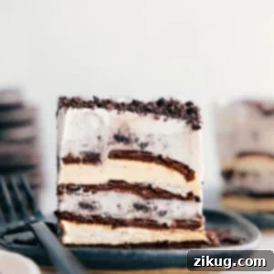 A perfectly sliced piece of four-ingredient Ice Cream Sandwich Cake on a white plate, showcasing its beautiful layers.