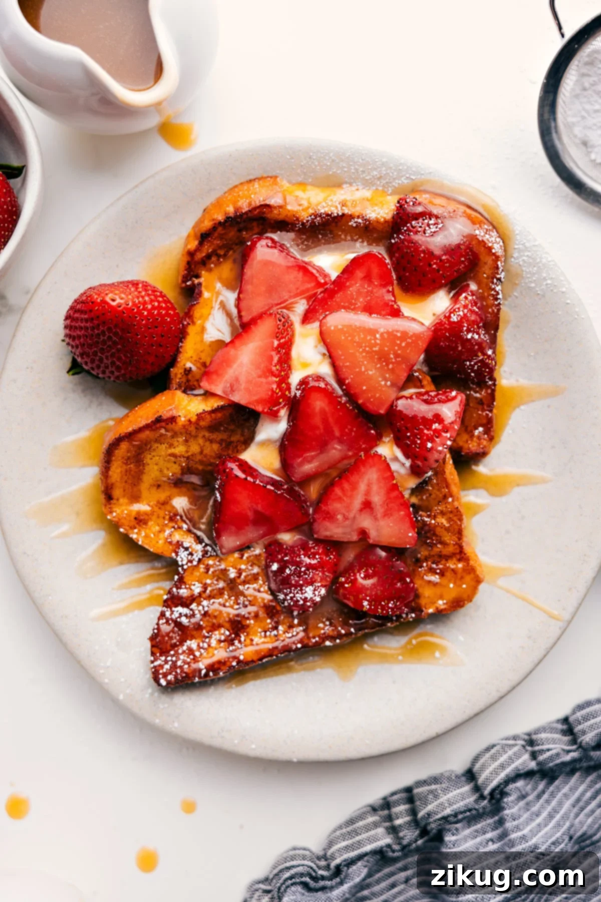 Decadent French Toast with Strawberries and Whipped Cream Golden-brown French Toast with a generous dollop of whipped cream, fresh sliced strawberries, and a rich caramel syrup drizzle.