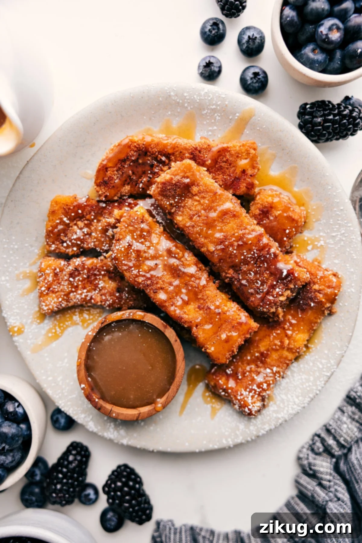 Cinnamon-Sugar French Toast Sticks Crispy Cinnamon-Sugar French Toast Sticks served on a plate with warm maple syrup and a dusting of powdered sugar, ready for a delightful breakfast.