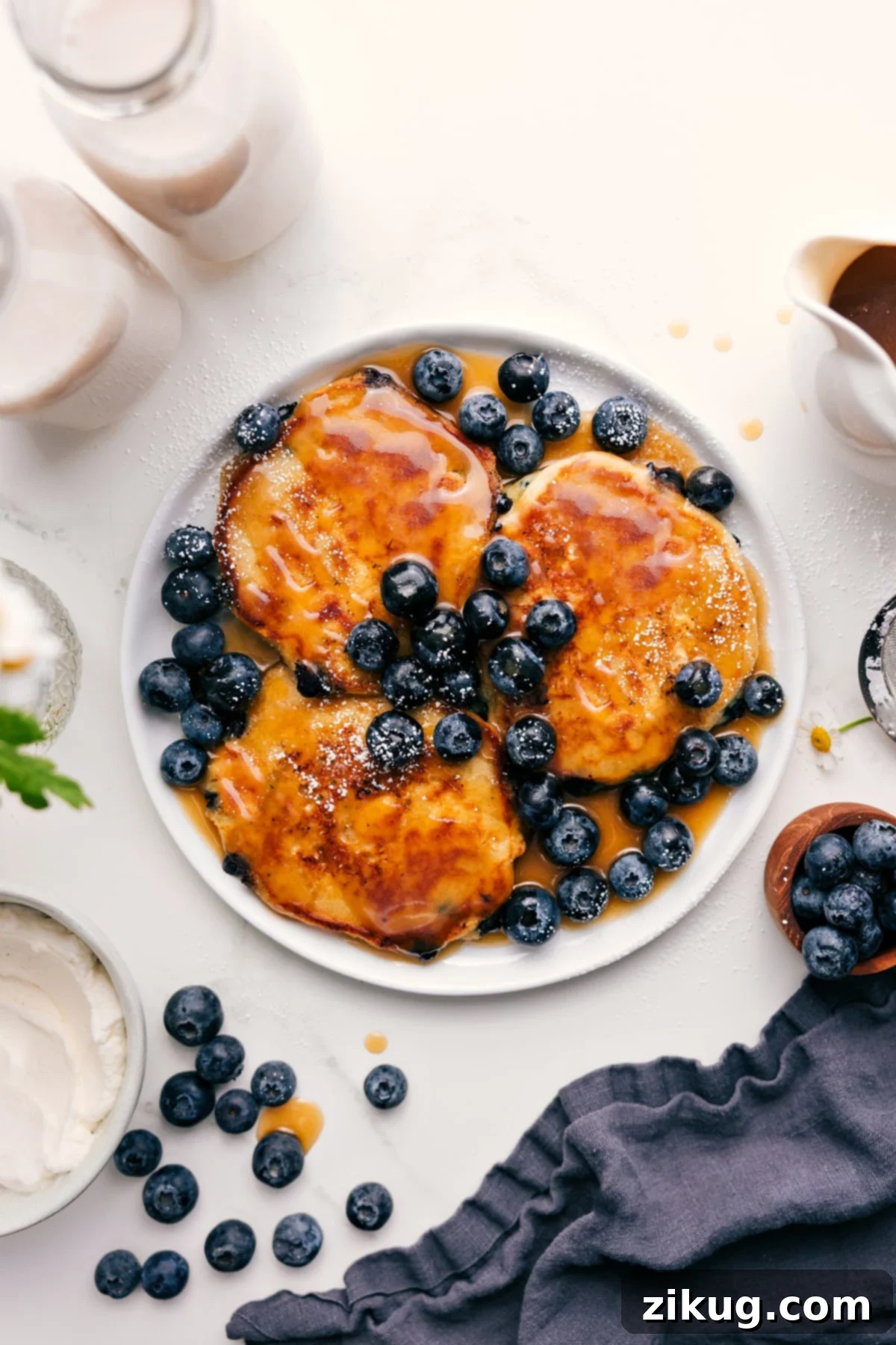 Blueberry Pancakes with Butter and Syrup Blueberry Pancake Recipe topped with fresh blueberries and pancake syrup, showcasing perfect golden-brown edges and fluffy texture.