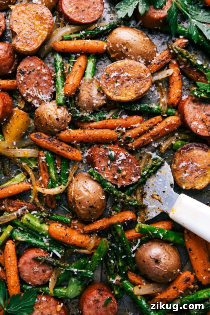 A vibrant Sheet Pan Sausage and Potatoes recipe featuring fresh spring produce like asparagus and carrots alongside savory sausage.