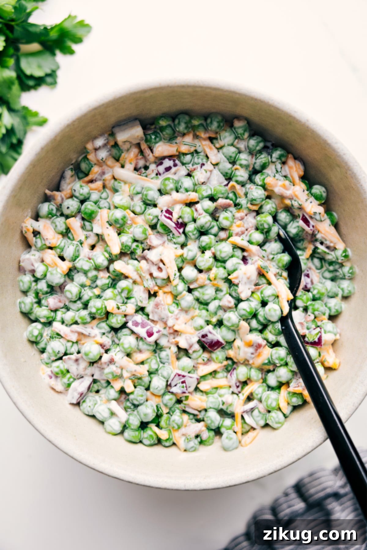 Creamy Pea Salad recipe in a rustic bowl, garnished with fresh dill and ready to be enjoyed as a perfect spring side dish.