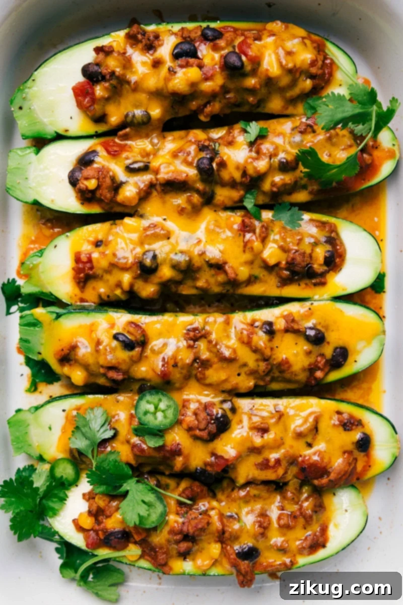 Mexican Zucchini Boats Finished Mexican Zucchini Boats, generously topped with melted cheese and fresh herbs, presenting a hearty and healthy meal.