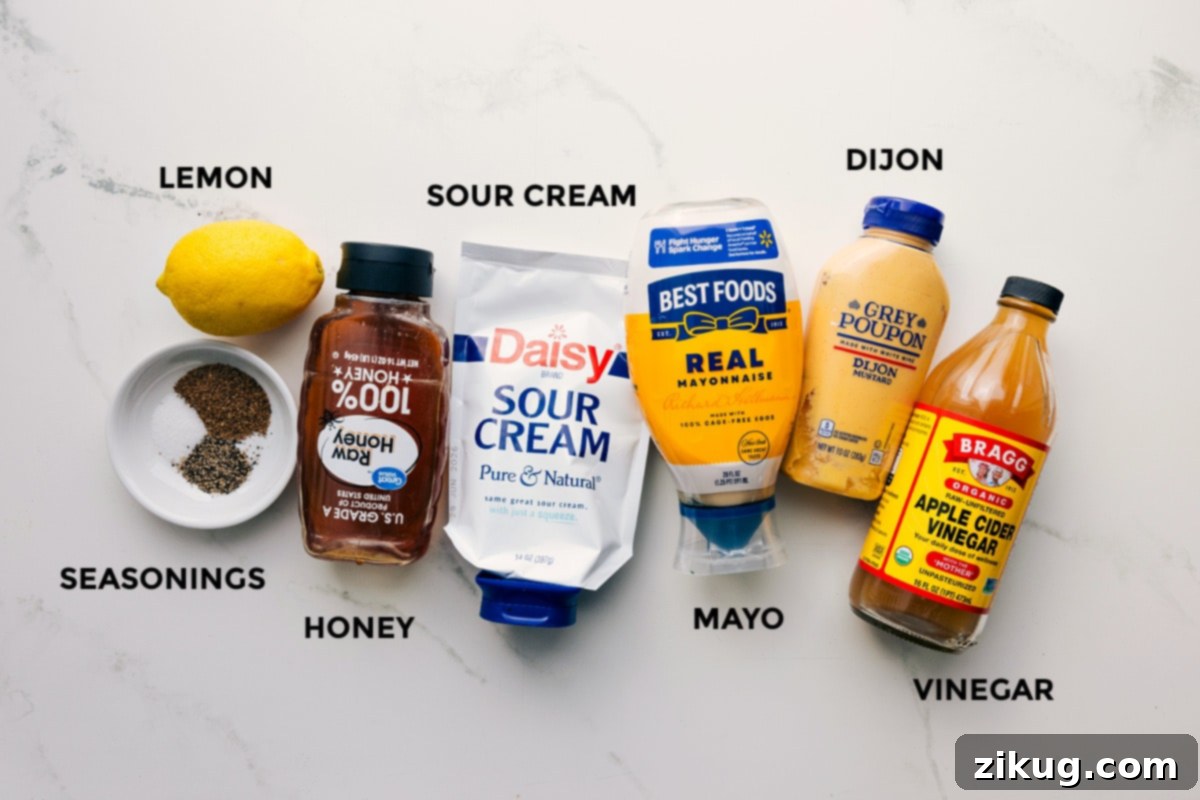 Ingredients In The Dressing For This Easy Coleslaw Dressing All the ingredients for the Easy Coleslaw Recipe dressing meticulously prepped and ready for mixing, including lemon, various seasonings, honey, sour cream, mayonnaise, Dijon mustard, and apple cider vinegar.