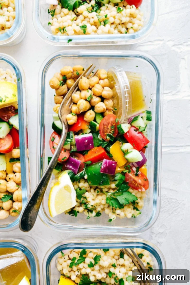 Mediterranean Greek Couscous Salad A delicious Greek couscous salad with chickpeas, packed into meal prep containers, ready for healthy and convenient meals.