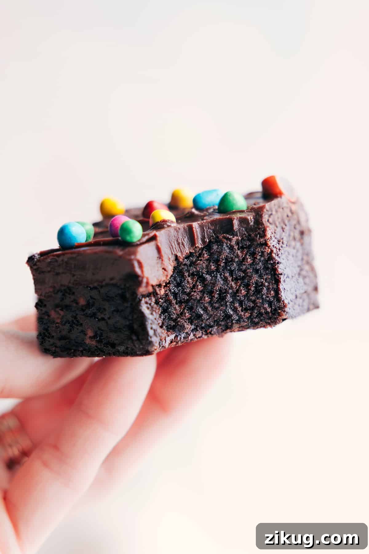 Fudgy And Flavorful Cosmic Brownies Recipe Cosmic Brownies Recipe held up with a large bite taken out of one brownie.