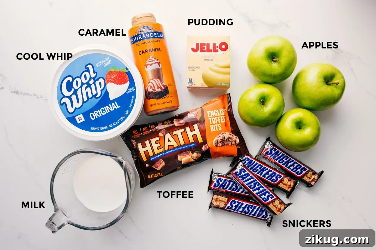 Ingredients In This Snickers Salad Recipe All the ingredients in this recipe prepped out for easy assembly including the milk, cool whip, caramel, toffee, snickers, apples, and jello.