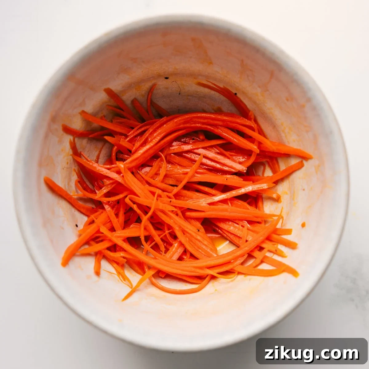 Carrots Tossed With Dressing The carrots being shredded and marinated in the dressing for this veggie sandwich.