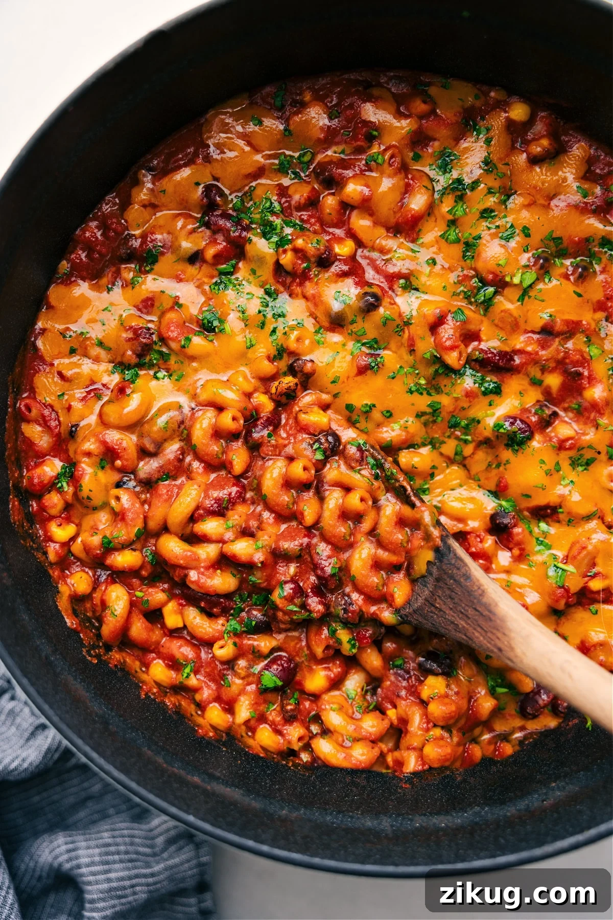 Vegetarian Chili Mac In A Pot Vegetarian recipes: vegetarian chili mac in a pot with melted cheese on top and a big scoop being served.