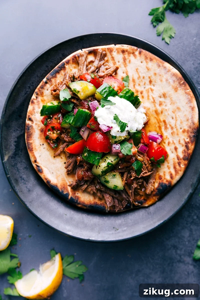 Shredded Beef Gyros Shredded beef gyros tucked into warm pita and topped with cucumber tomato salad and creamy tzatziki sauce.