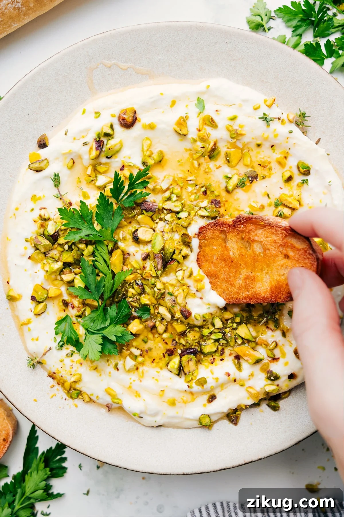 Whipped Feta Recipe Greek recipes: Whipped feta recipe with pistachios on top with a piece of bread dipping in.