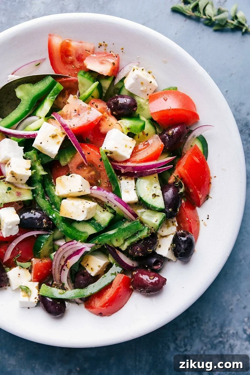 Fresh Greek Salad Recipe Greek Recipes Fresh greek salad in a bowl with tomatoes, olives, feta cheese, and cucumbers.