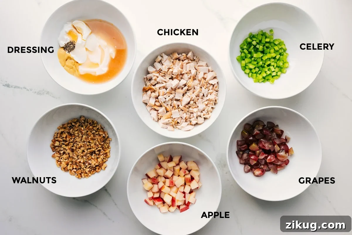 Ingredients In This Waldorf Chicken Salad All the ingredients prepped out for easy assembly including the dressing, walnuts, apple, chicken, grapes, and celery.