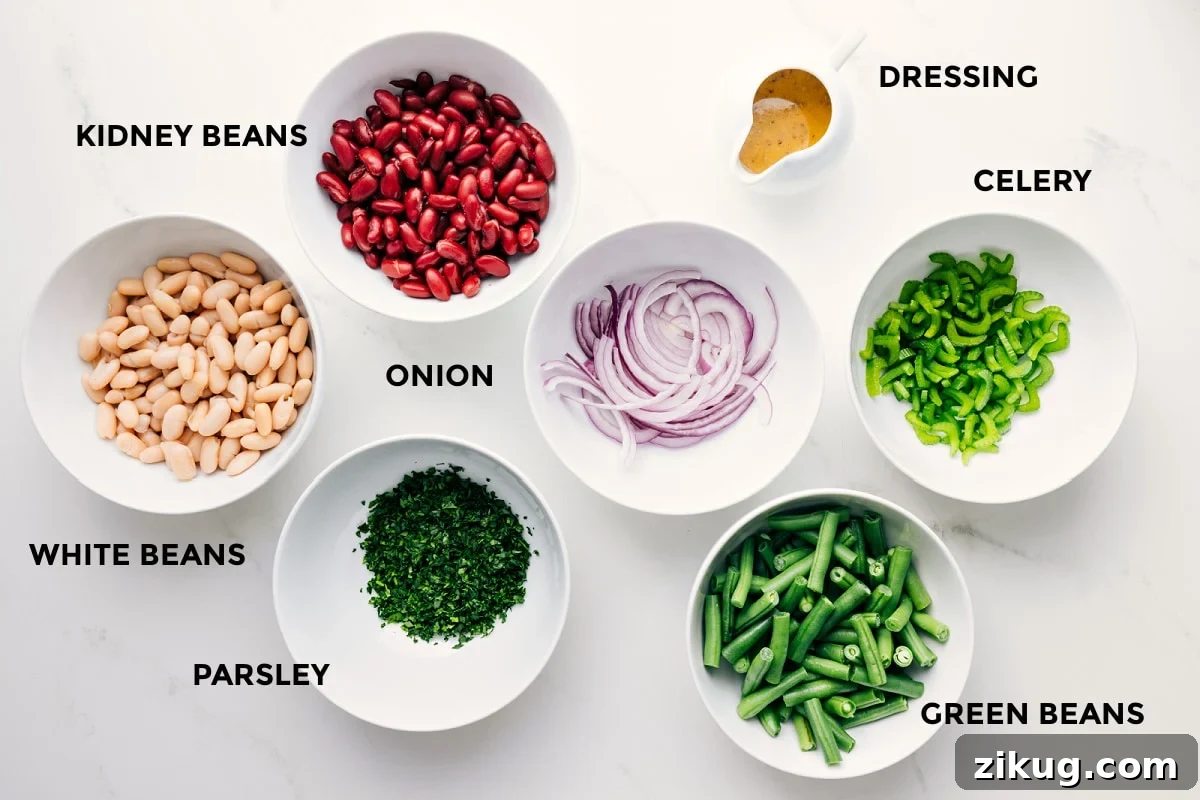 Ingredients In This Three Bean Salad All the ingredients in this recipe prepped out for easy assembly including the beans, parsley, onion, green beans, celery, and dressing.