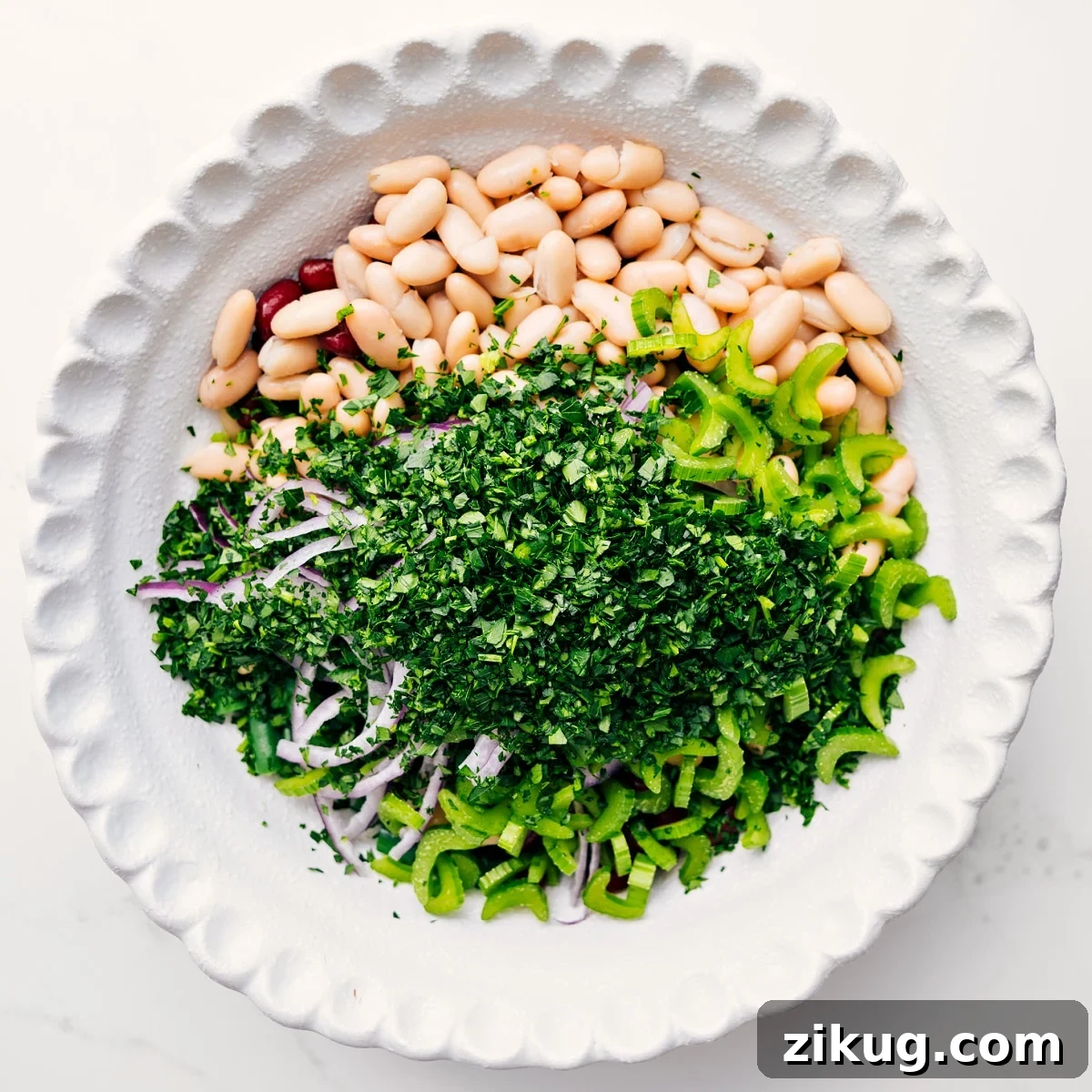 How To Make This Three Bean Salad Three bean salad ingredients added to a bowl, ready to be tossed with dressing.