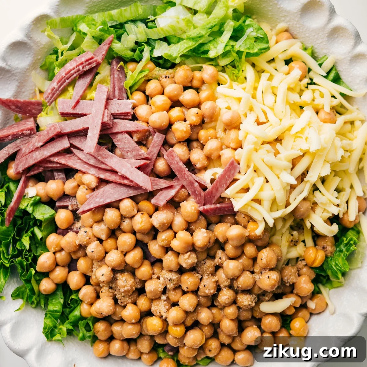 La Scala Chopped Salad In A Bowl Ready To Be Tossed The salad ingredients in a bowl with dressing, ready to be tossed.