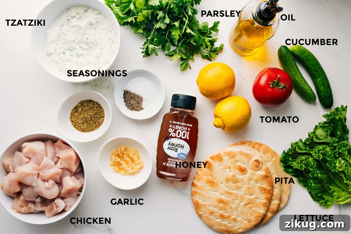 Ingredients In Chicken Souvlaki All the ingredients in this recipe prepped out for easy assembly including the tzatziki, seasonings, chicken, garlic, honey, pita, lettuce, tomato, cucumber, lemon, oil, parsley.