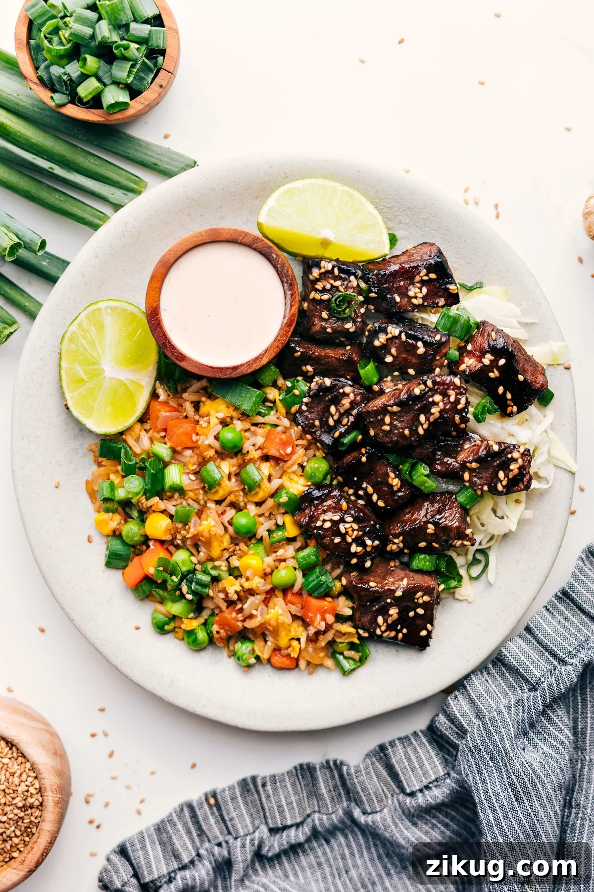Make Hibachi At Home With These Hibachi Steak Bowls Hibachi steak bowl served over cabbage with fried rice and dipping sauce on the side.