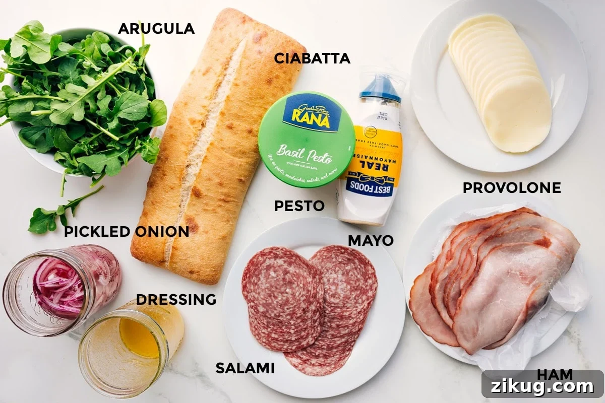 Ingredients In This Ciabatta Sandwich All the ingredients in this recipe prepped out for easy assembly including the arugula, pickled onions, dressing, ciabatta, pesto, mayo, salami, ham, and provolone.
