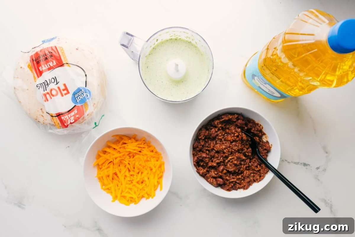 Crispy Beef Tacos with Avocado Cilantro Slaw 4 All the ingredients in this recipe prepped out for easy assembly including the tortillas, cheese, sauce, beef, and oil.