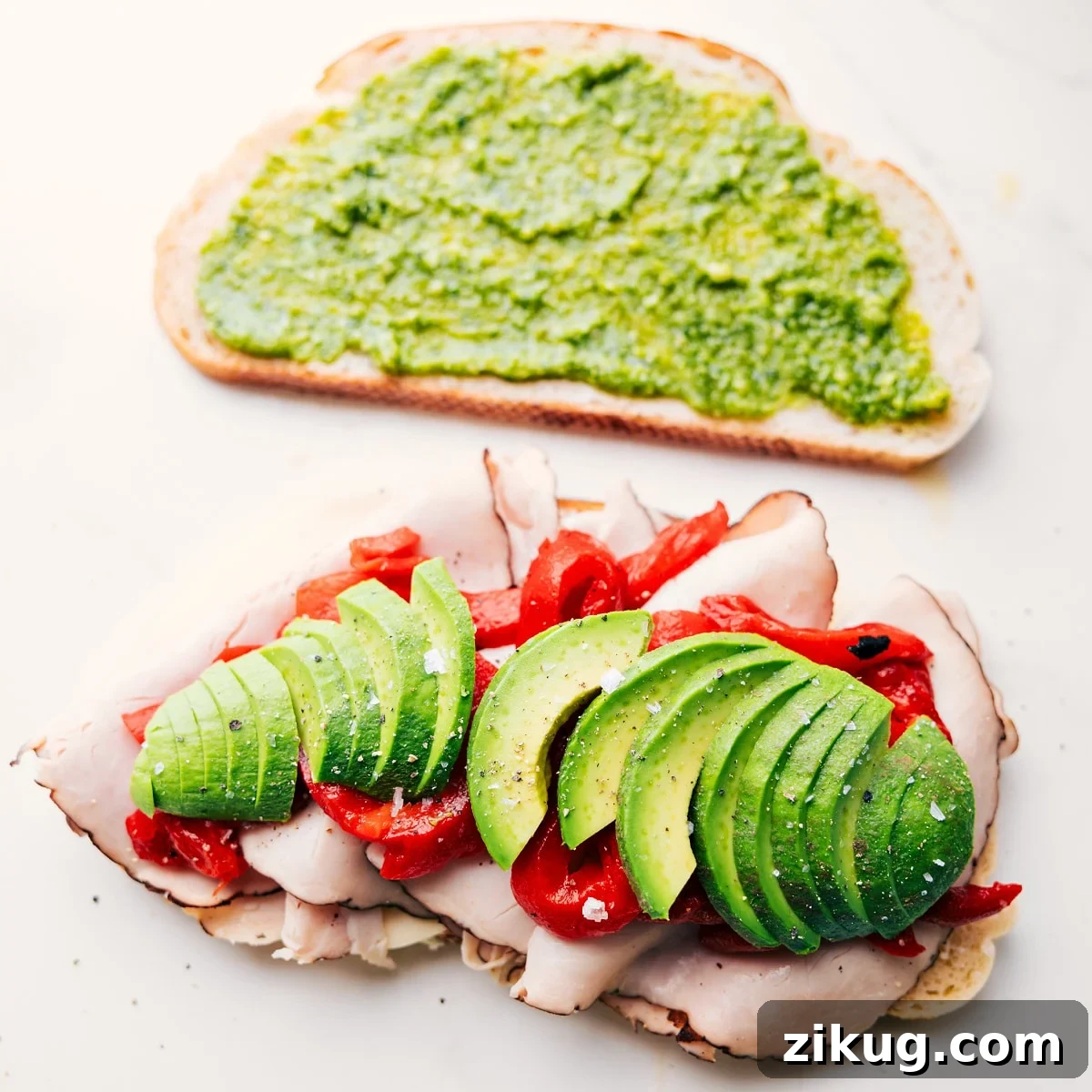 Panini Recipes: Flavorful Grilled Sandwich Ideas 5 Preparing Panini Sandwich Recipes by layering turkey, cheese, avocado, roasted peppers, arugula, and pesto onto sliced bread.