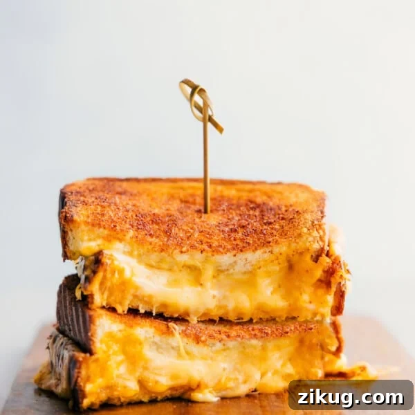 Grilled Cheese stacked on top of each other showing the cheesy center.