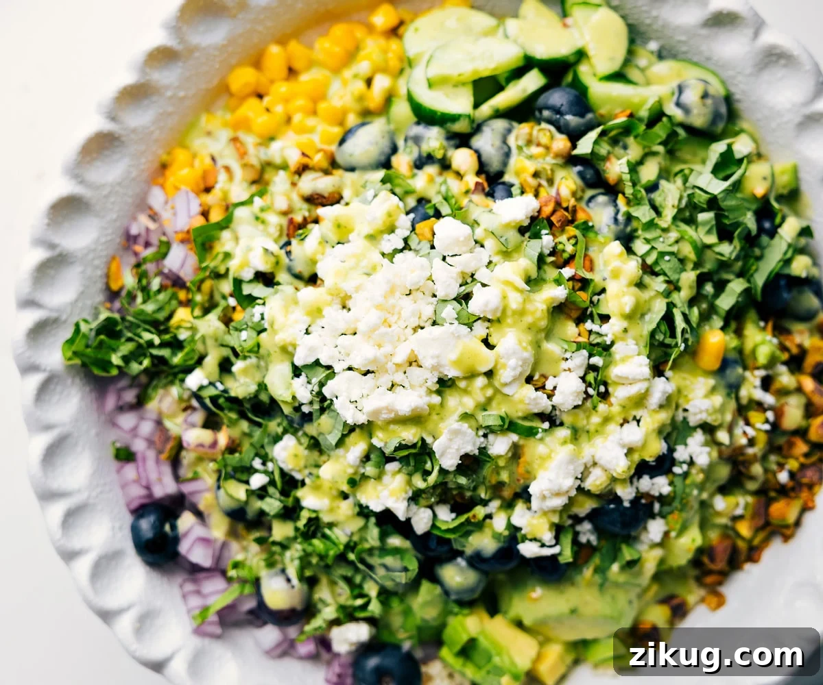 How To Make This Blueberry Salad Blueberry salad ingredients added to a bowl with dressing drizzled over the top.