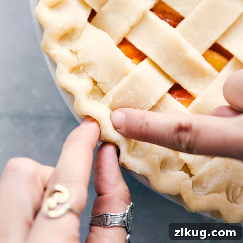 Fresh Peach Pie with Flaky Buttery Crust 4 The crust's edge being shaped into a beautiful pattern, adding an artistic touch.