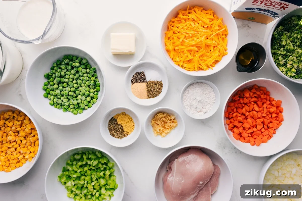 Creamy Chicken Soup with Tender Shredded Chicken 4 All the ingredients in this recipe prepped out for easy assembly including the milk, peas, corn, celery, seasonings, butter, chicken, cheese, carrots, onions, broccoli, oil, and stock.