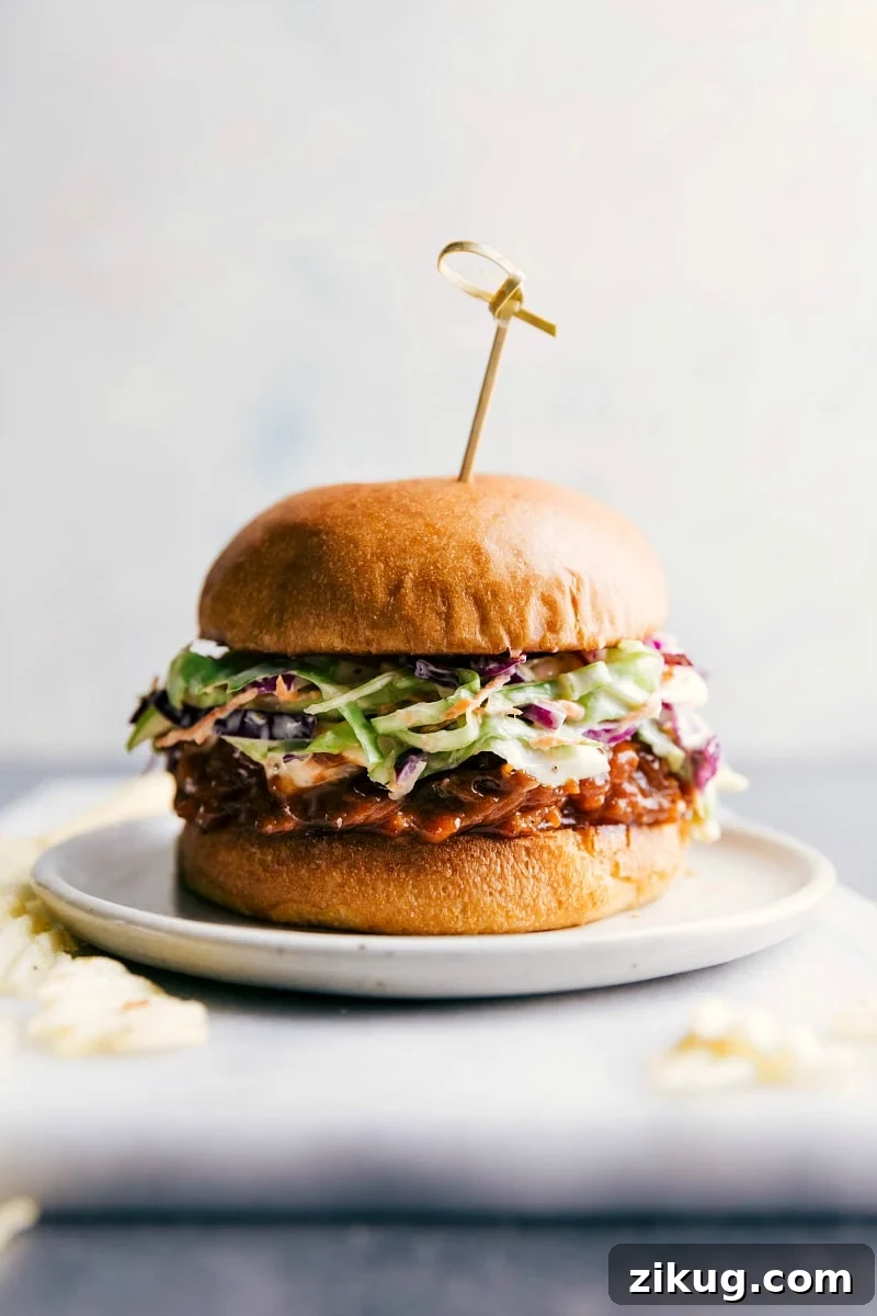 Street Corn Beef Bowls Crockpot BBQ pulled pork sandwich on a plate, overflowing with delicious ingredients, ready to be enjoyed.